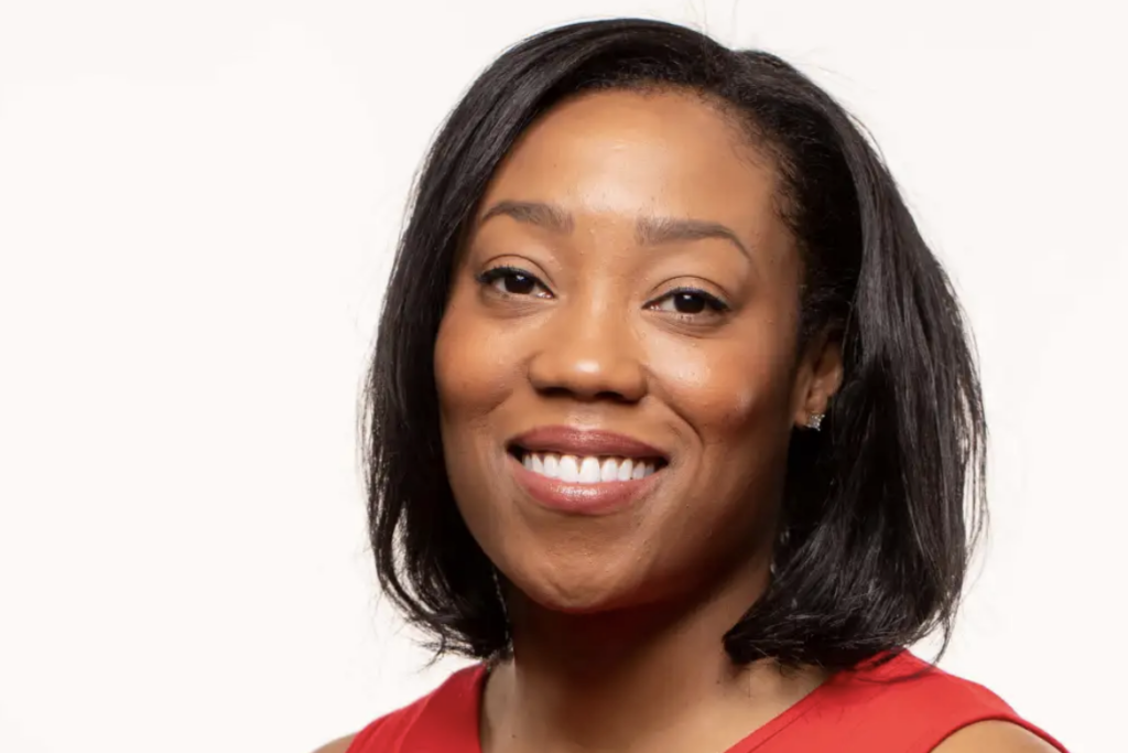 A headshot of Traci Parker wearing a red blouse.