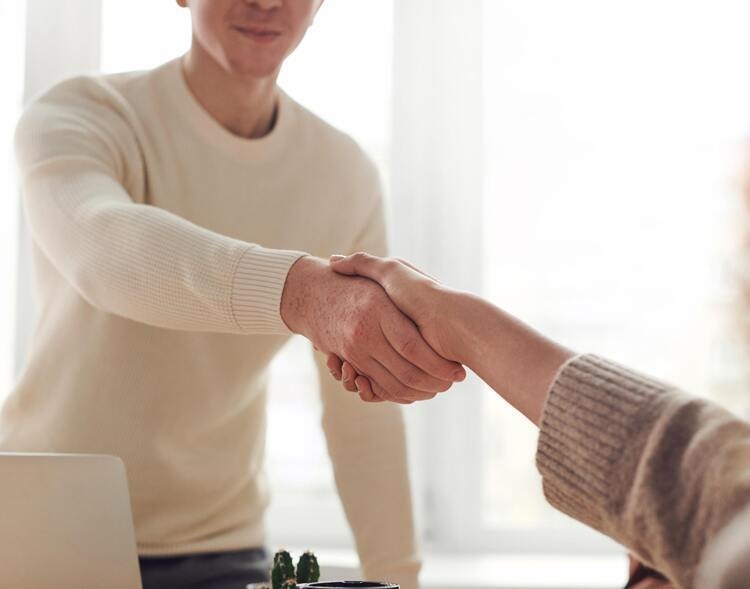 A photo of two white people shaking hands.